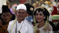 Peserta nikah massal tersenyum bahagia setelah sah menjadi suami istri.