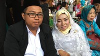 Berbeda dengan pasangan lain yang busanannya disiapkan oleh kelurahan, Mira Chasmirah dan pasangannya lebih memilih pakai busana sendiri. Dia tampil simpel dengan busana putih dipadu kerudung.