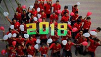 Tak sendirian, gadis ini merayakannya bersama teman-temannya di sekolah. Mereka membawa balon dan angka 2018 (Foto: REUTERS/Amit Dave)