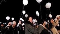 Warga memegang balon sambil menunggu pergantian tahun di Tokyo, Jepang (Foto: REUTERS/Toru Hanai)
