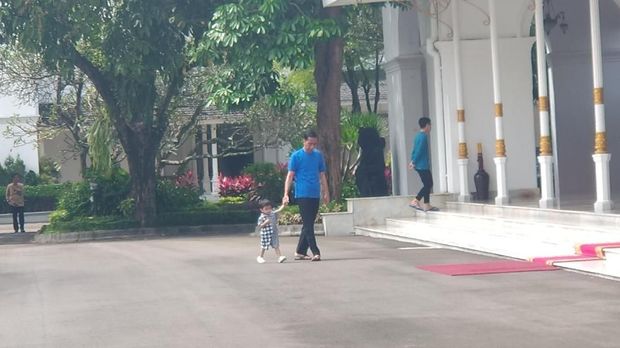  Jokowi berkaus biru dan bersandal jepit di depan Gedung Agung alias Istana Kepresidenan Yogyakarta.
