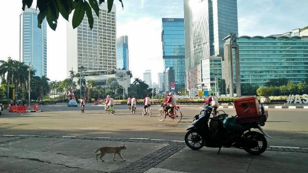Warga berolahraga di sekitaran Bundaran HI menikmati pagi nan cerah.