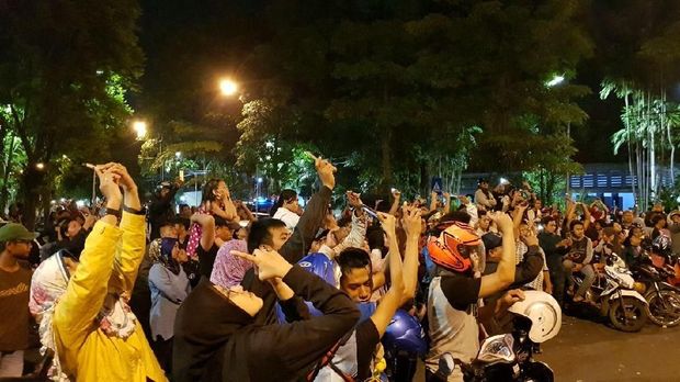 Warga mengarahkan ponselnya ke arah kembang api terlontar