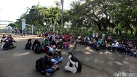Sambil menunggu gerbang dibuka, mereka duduk-duduk sambil mengobrol.