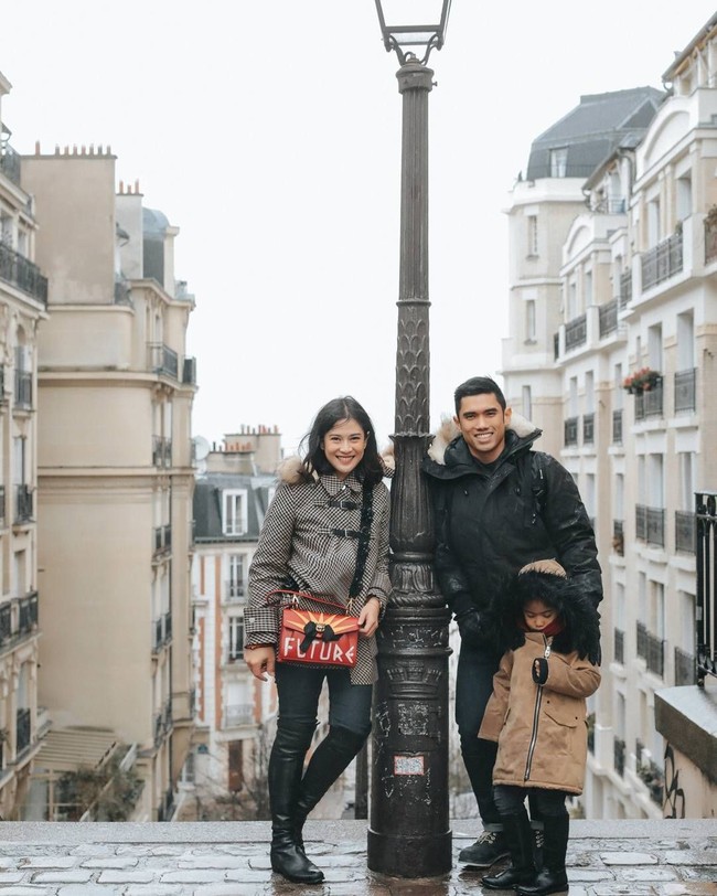 Mengenakan coat, high knee boots hitam dan tas Gucci bertuliskan Future, Dian Sastro, suami dan anaknya berpose bersama di Montmartre, Paris. Foto: Instagram