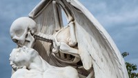 Patung The Death Kiss berdiri si atas makam seorang pemuda yang meninggal pada tahun 1930-an di Barcelona, Spanyol. Banyak cerita yang mengatakan patung ini menginspirasi Ingmar Bergman menciptakan film The Seventh Seal. (Thinkstock)