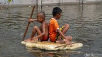 Beberapa anak-anak memanfaatkan banjir rob untuk bermain. Mereka bahkan membuat perahu sederhana dari Styrofoam.