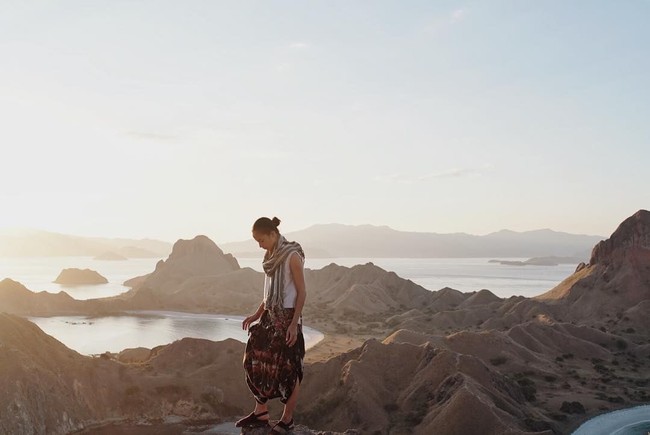 Ketika bepergian, busana berwarna netral memang paling tepat diandalkan. Agar gaya lebih menarik, Anda bisa menambahkan bawahan bermotif dan syal seperti Putri Marino. Foto: Instagram Putri Marino