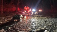 Sebuah mobil bahkan terjebak disebuah jalan yang dipenuhi es di Maryland, Amerika Serikat. Petugas pemadam kebakaran setempat langsung turun tangan. Montgomery County Fire and Rescue Service/Social Media/via REUTERS.