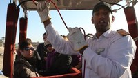 Aktivitas wisata balon udara semacam ini pernah dihentikan otoritas Mesir setelah terjadi dua kecelakaan fatal beberapa tahun lalu. Foto menunjukkan seorang pilot balon udara menjalankan tugasnya dalam wisata di Mesir tahun 2009 lalu. Foto: AFP PHOTO/Cris BOURONCLE