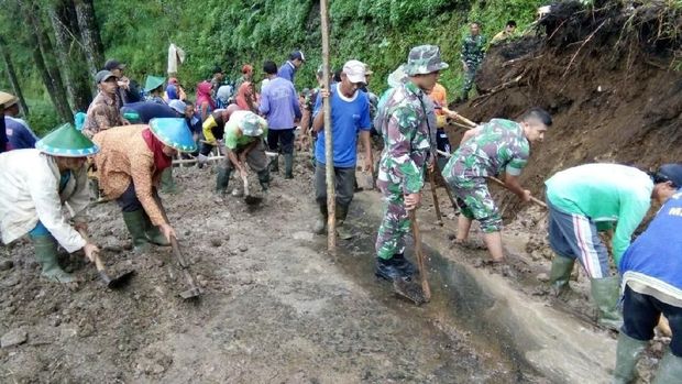 Warga dan aparat berusaha membersihkan longsor yang tutupi jalan