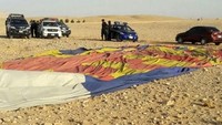 Sebuah balon udara yang membawa 20 penumpang, termasuk para wisatawan, jatuh di dekat Luxor, Mesir. Dalam foto ini, terlihat bagian parasut atau envelope balon udara yang jatuh telah mengempis di tanah. Foto: AFP PHOTO/STRINGER