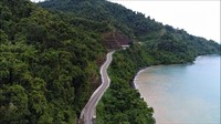 Selain menyusur pantai, jalan di ruas Ransiki-Mameh ini juga dipagari bukit penuh rimbunan pohon. Foto: Dok. BP Jalan Nasional XVII Manokwari-Papua Barat