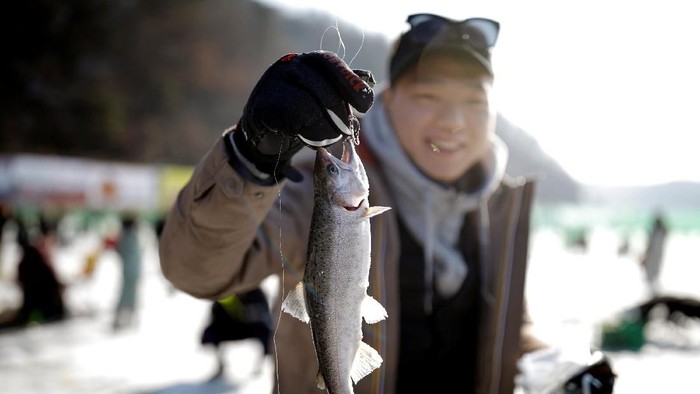 A boy reacts after catching a trout with his hands during an event promoting the Ice Festival in Hwacheon, south of the demilitarized zone (DMZ) separating the two Koreas, South Korea January 6, 2018. REUTERS/Kim Hong-Ji
