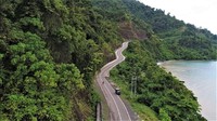 Hamparan laut biru dan bukit dengan rimbunan pohon mengapit jalan di ruas Ransiki-Mameh ke arah Bintuni ini. Foto: Dok. BP Jalan Nasional XVII Manokwari-Papua Barat