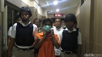 Acep tampak mengenakan baju tahanan dan bermasker serta dikawal polisi (Foto: Mei Amelia/detikcom)