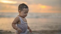 Si bungsu terlihat senang bermain di pantai hanya mengenakan kaos dalam dan popok. (Foto: dok. Instagram Ashanty)