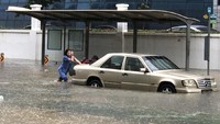 Seorang wanita setempat terpaksa mendorong mobil di tengah genangan banjir di Bedok North, Singapura. Foto: Channel News Asia/Twitter/@SynCPositive