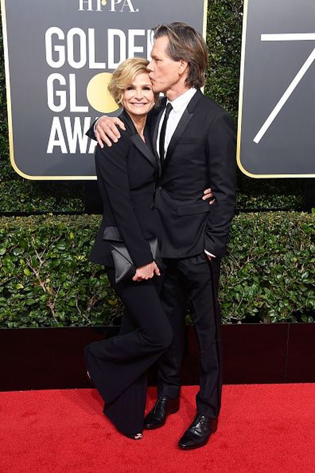 Selain Claire Foy, aktris senior Kyra Sedwick juga datang ke red carpet Golden Globes 2018 dengan setelan jas. Terlihat elegan, ia pun menambahkan clutch bermaterial satin. Foto: Getty Images