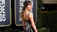 Dakota Johnson juga jadi sorotan karena dress hitam dan penampilannya yang menawan di ajang tersebut. Frazer Harrison/Getty Images