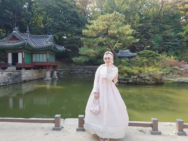 Ini gaya feminin Kim Miso saat memakai hanbok yang merupakan baju tradisional Korea. Ia memilih hanbok warna merah muda disesuaikan dengan kerudungnya dengan pilihan palet dasar serupa. Foto: Dok. Instagram @kimmiso1194