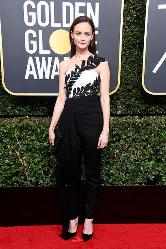 Jika biasanya para aktris mengenakan gaun di acara karpet merah, Alexis Bledel tampil berbeda. Pada Golden Globes 2018, Alexis memilih mengenakan jumpsuit keluaran Oscar de La Renta. Gaun itu tampak cantik dengan detail bunga di bagian atas dan selendang di pinggang. Foto: Getty Images
