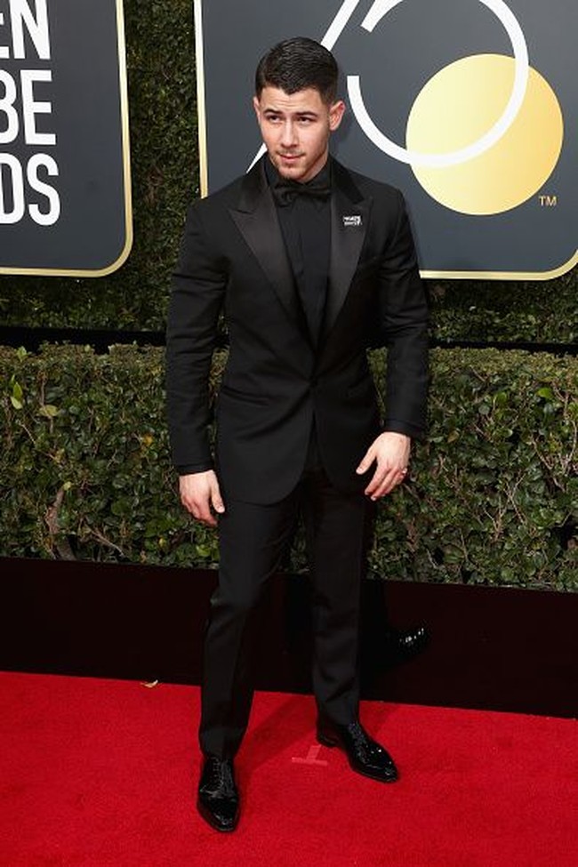 Nick Jonas yang tengah dikabarkan sedang dekat dengan Demi Moore juga memilih tampil serba hitam. Pemain film Jumanji: Welcome to the Jungle tersebut memilih jas dengan lapel bermaterial mengkilap. Foto: Getty Images