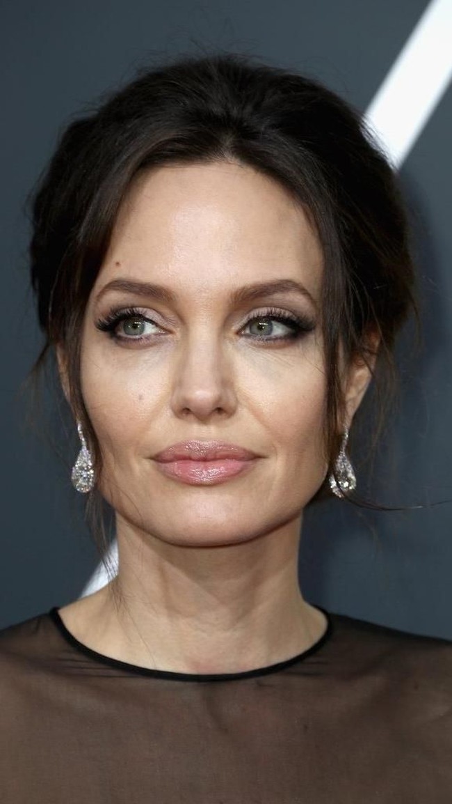Angelina Jolie menjadi salah satu seleb yang penampilannya paling ditunggu-tunggu di Golden Globes. Tampil dengan lipstik nude dan riasan bernuansa smokey, Jolie tetap memberikan aura seksinya. Foto: Getty Images