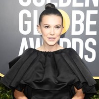 Bintang Stranger Things Millie Bobby Brown, memukau di red carpet dengan winged eyeliner dan tatan rambut cepol tinggi.  Foto: Getty Images