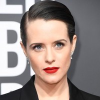 Tampil maskulin dengan setelan jas, Claire Foy menyeimbangkan sisi feminis dengan lipstik merah.  Foto: Getty Images