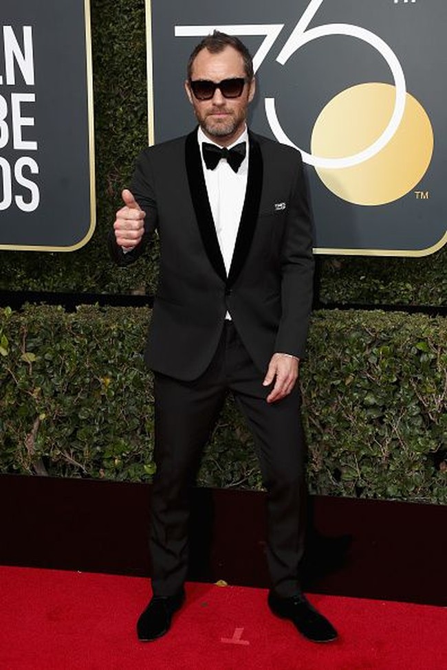 Meski sudah tidak muda, pesona dan ketampanan Jude Law belum memudar. Di red carpet Golden Globes 2018 ia sempat memakai kacamata untuk melengkapi gaya elegannya mengenakan setelan jas dan celana hitam. Foto: Getty Images
