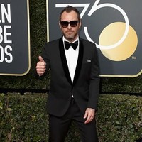 Meski sudah tidak muda, pesona dan ketampanan Jude Law belum memudar. Di red carpet Golden Globes 2018 ia sempat memakai kacamata untuk melengkapi gaya elegannya mengenakan setelan jas dan celana hitam. Foto: Getty Images