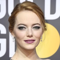 Tampil dengan smokey eyes bernuansa hijau dan lipstik ungu, ternyata ada makna feminis pada makeup Emma Stone.  Foto: dok. Getty Images