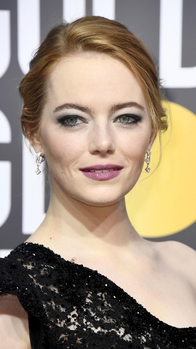 Tampil dengan smokey eyes bernuansa hijau dan lipstik ungu, ternyata ada makna feminis pada makeup Emma Stone.  Foto: dok. Getty Images