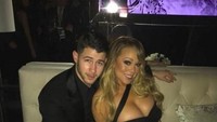 Dua gelas red wine terlihat menemani kebersamaan Mariah Carey dan Nick Jonas. Keduanya kompak mengenakan outfit serba hitam.