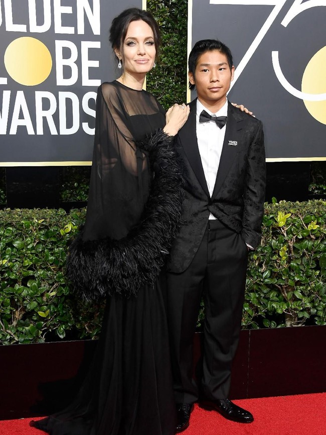 Saat datang ke Golden Globes, Angelina Jolie didampingi anaknya, Pax Thien. Bros Time’s Up tampak menghiasi jas Pax Thien, anak yang diadopsi Jolie dari Vietnam itu. (Foto: Getty Images)