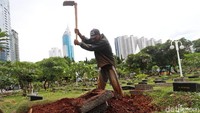 Pekerja membersihkan makam di TPU Karet Bivak, Jakarta, Selasa (9/1/2018).