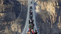 Jembatan Kaca Hongyagu juga sangat memacu adrenalin. Soalnya, jembatan kaca itu ditahan oleh sejumlah tali elastis yang bisa bergoyang seiring dengan langkah kaki pengunjung yang berjalan di atasnya (Zhang Haiqiang/VCG via Getty Images)