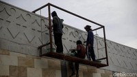 Beberapa pekerja tengah mengerjakan ornamen jembatan.