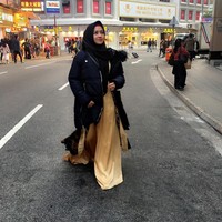 Seperti ini gaya hijab Shinta Tanjung ketika liburan ke Hong Kong dan tetap syari. Gamis panjangnya dipadukan dengan jaket tebal agar tak terlihat mencolok. Ia memakai kerudung hitam supaya tetap netral. Foto: Dok. Instagram @chintatanjung