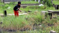 Seorang bocah memancing di Pemakaman Tanah Kusir, Jakarta Selatan, Selasa (9/1/2018).