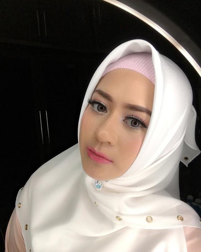 Cantiknya Shinta Tanjung dalam pulasan makeup bernuansa merah muda. Ia menerapkan kerudung yang dikreasikan dengan bros di bawah dagu serta menggunakan ciput rajut yang tren. Foto: Dok. Instagram @chintatanjung