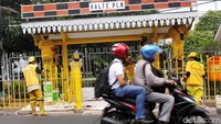Pengendara melintas di depan halte yang tengah dicat.