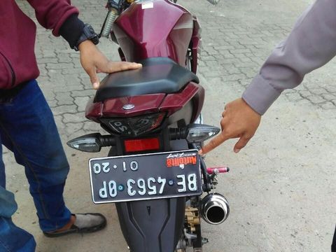 Pelat nomor kendaraan itu sengaja dipasang terbalik. Sementara di bagian depan sepeda motor, pelat nomor tak dipasang