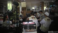 Ada belasan penyidik KPK yang datang. Mereka mengenakan rompi KPK. Terlihat juga anggota polisi di dalam ruangan. Foto: Indra Komara/detikcom
