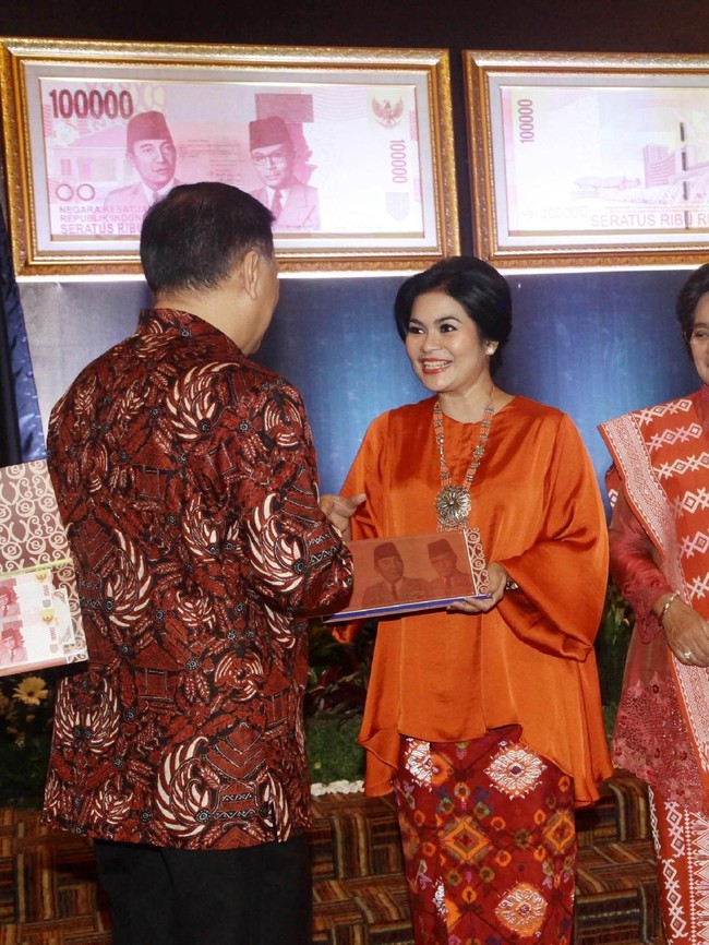 Puti Guntur Soekarno tampak cantik dalam balutan baju kurung oranye dengan batik jumputan berwarna senada saat menerima uang pecahan khusus dari Gubernur Bank Indonesia (BI) Agus Martowardojo 2014 silam. (Foto: detikfoto/Hasan Alhabshy)