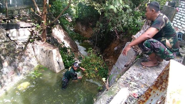 Tumbuhan liar dan sampah menghambat aliran air danau mengalir ke saluran pembuangan