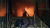 Petugas pemadam menggunakan alat bantu pernapasan saat bekerja. Menurut Coleman, api saat ini juga telah mencapai kawasan jalan penghubung antara gedung stasiun lama dan baru.  (Foto: Dok. Nottingham Fire and Rescue)