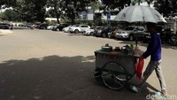 Hanya pedagang dorong yang terlihat melintas.