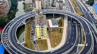 Di Guangzhou, pihak berwenang harus membangun jalan lingkar di sekitar blok rumah susun ini karena si pemilik tak menjual rumah tersebut. Boredpanda/Istimewa.